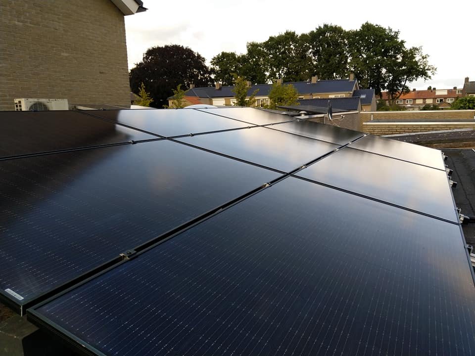 Full black zonnepanelen op een dak in avondlicht