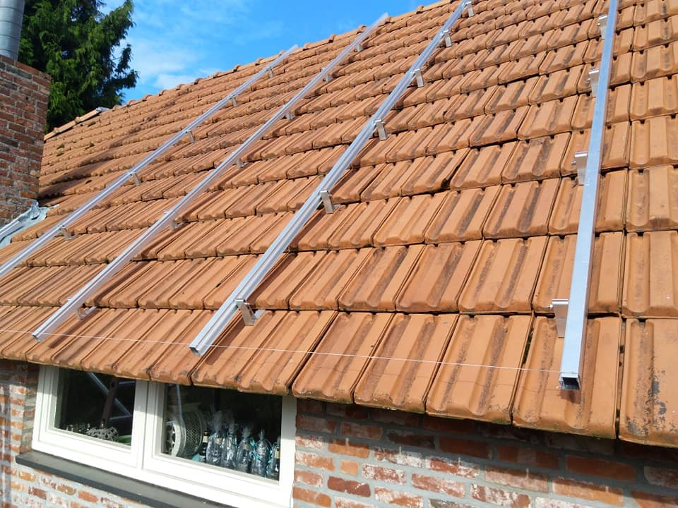 Montagerails gemonteerd op een oranje pannendak
