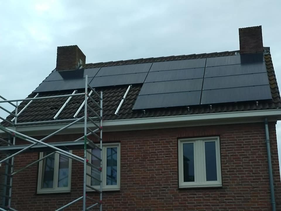 Zwarte zonnepanelen op een pannendak terwijl de steiger nog staat