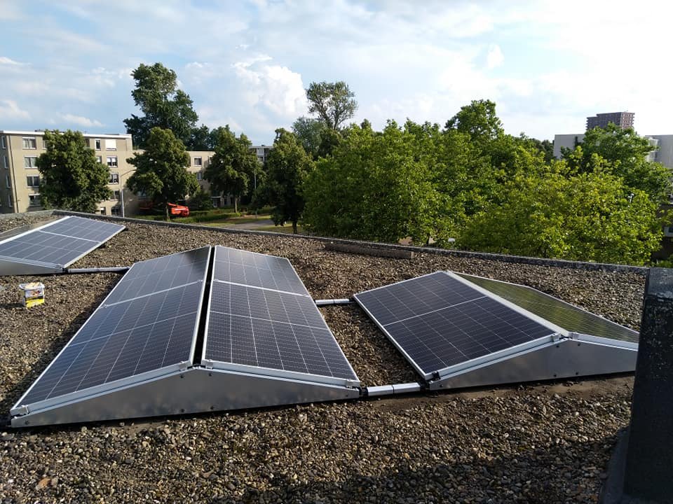 Drie losse opstellingen met zonnepanelen op een grinddak