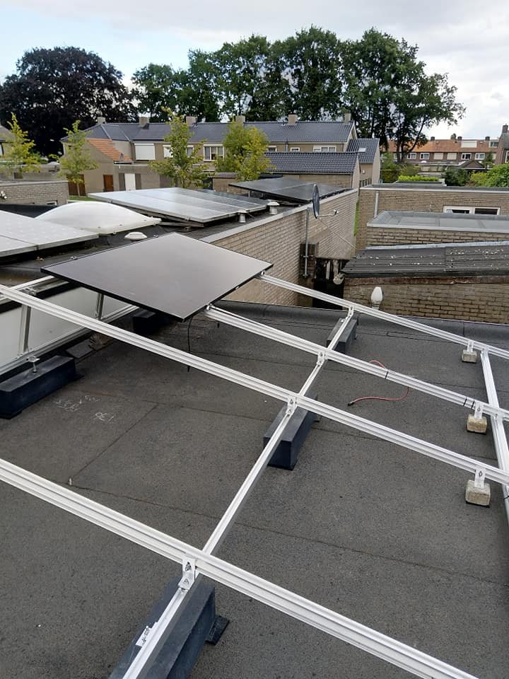 Montageframe in opbouw op een plat dak met het eerste paneel geplaatst
