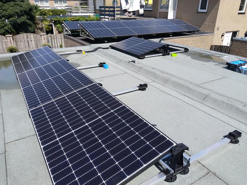 Twee rijen zonnepanelen op het platte dak van een woning