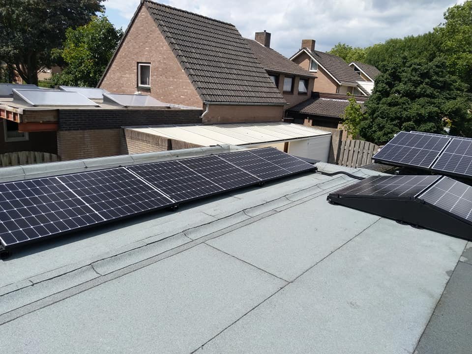 Zwart opstelframe met zonnepanelen op een plat dak
