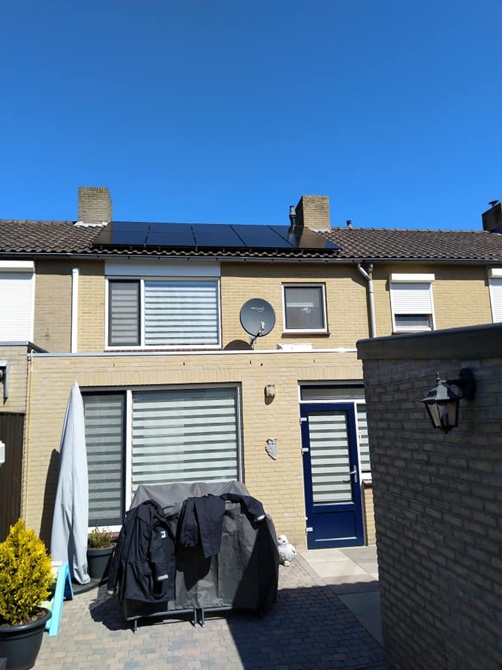 Rij zwarte zonnepanelen op het dak van een tussenwoning